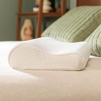 Tempur-pedic neck pillow sitting on bed